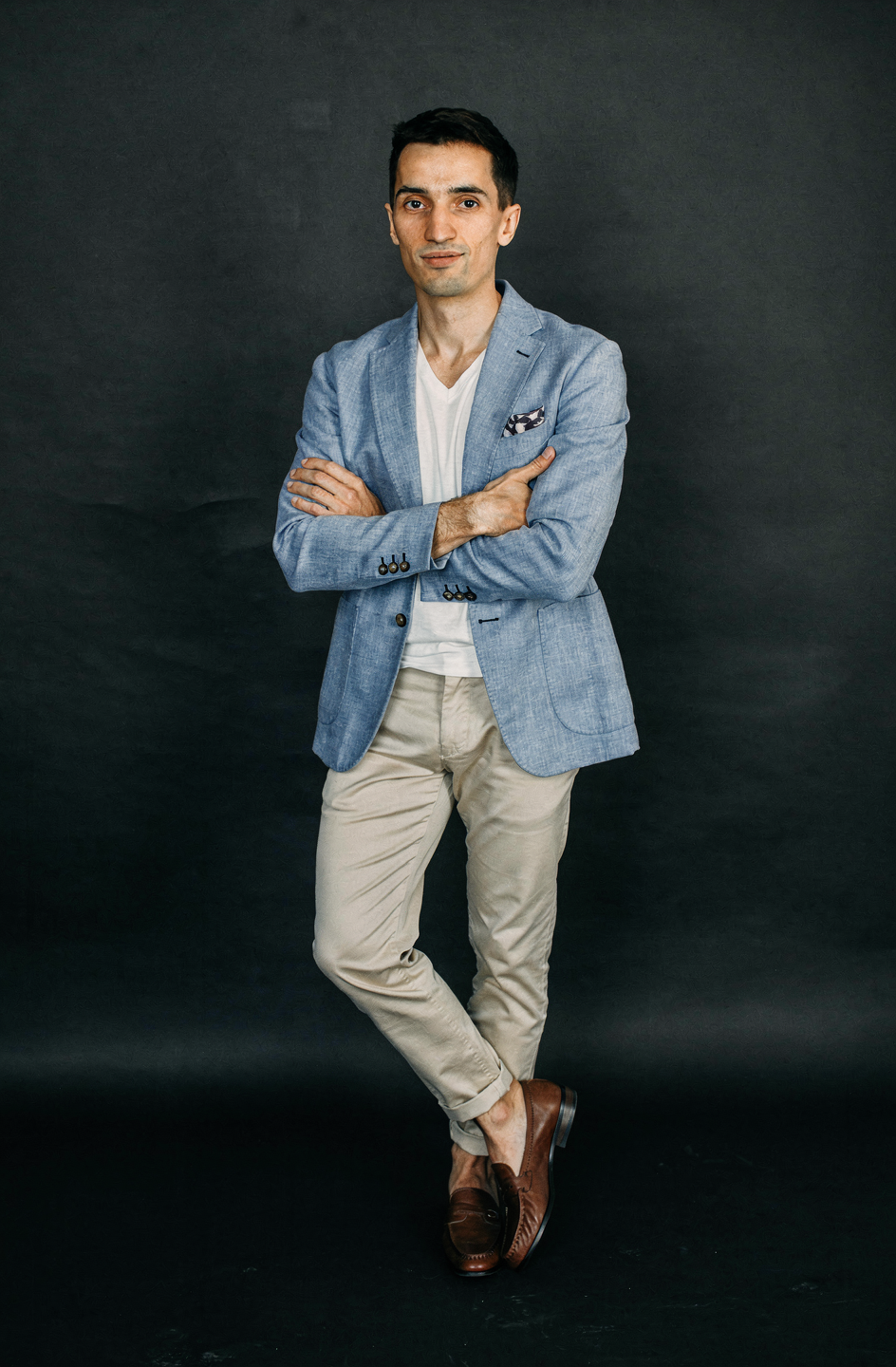 portrait of a confident man in a light blue blazer with crossed arms, professional photography